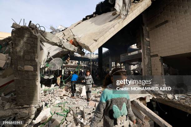 People inspect the damage in the rubble of a mosque following Israeli bombardment, in Rafah, on the southern Gaza Strip on February 12 amid ongoing...