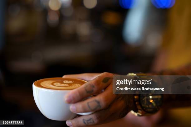 barista serving latte hot drink with heart milk froth art create - personal perspective or pov ストックフォトと画像