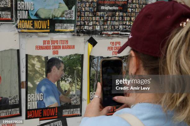 Woman takes a photo of a poster showing rescued hostage Fernando Marman on a wall at Hostages Square on February 12, 2024 in Tel Aviv, Israel. The...