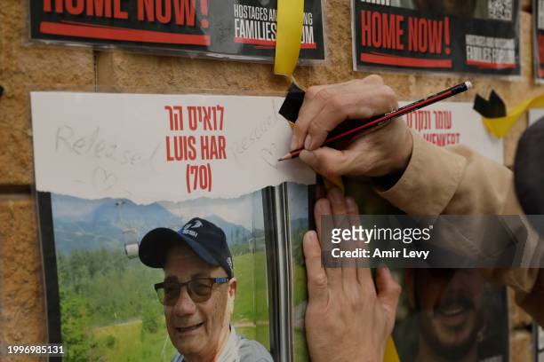 Man writes released and rescued on a poster of missing Israeli, Louis Har on a wall at Hostages Square on February 12, 2024 in Tel Aviv, Israel. The...