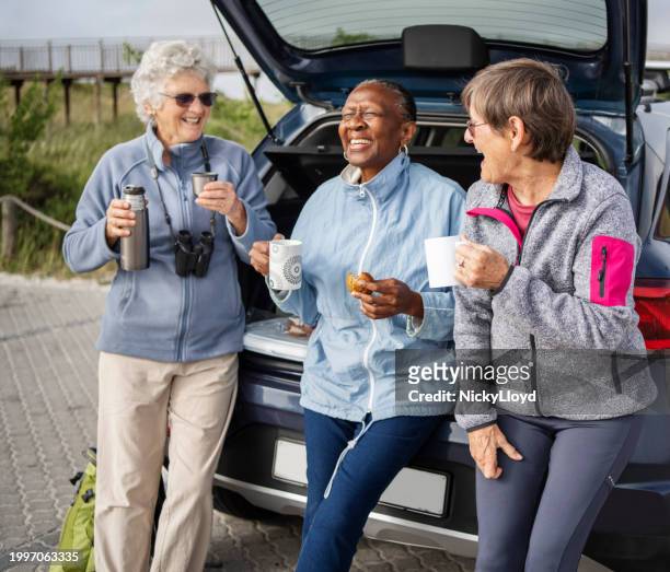 senior women laughing during a meal break during a road trip together - group laughing stock pictures, royalty-free photos & images