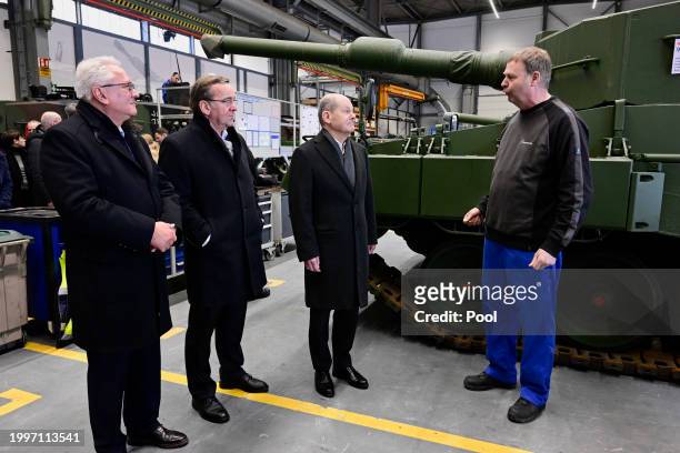 Of Rheinmetall Armin Papperger, German Defence Minister Boris Pistorius and German Chancellor Olaf Scholz talk to an employee during the...