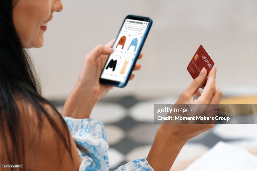Young woman using smartphone with credit card for internet banking. Blithe