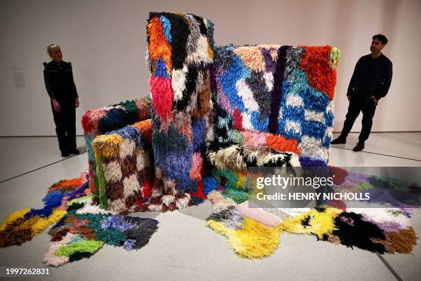 Visitors look at a piece by US and Peruvian artist Sarah Zapata called "To Teach or Assume Authority" during a press preview ahead of the exhibition...