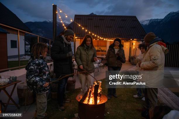 family enjoying the outdoors fireplace - slovenia night stock pictures, royalty-free photos & images