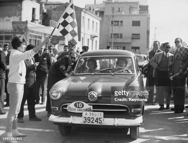 Efi Mela, former Miss Greece contestant at the 1954 Miss World competition waves the chequered flag to two female competitors before the start of the...