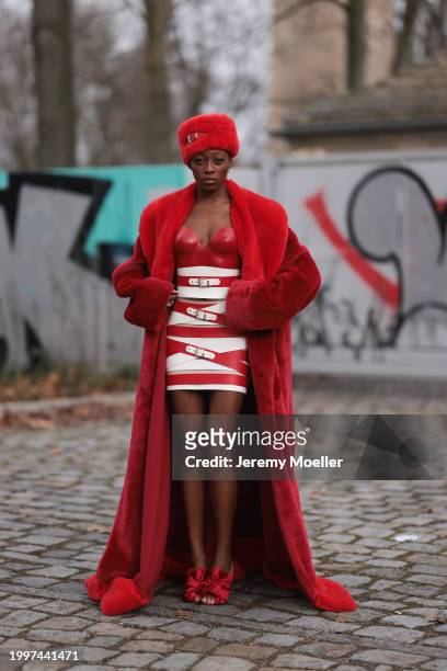Toni Dreher seen wearing Marina Hoermanseder red belted fake fur fluffy hat, Marina Hoermanseder red / white leather striped belted corset short...