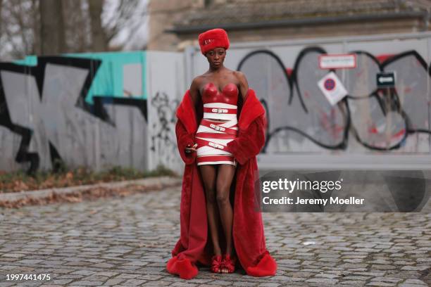 Toni Dreher seen wearing Marina Hoermanseder red belted fake fur fluffy hat, Marina Hoermanseder red / white leather striped belted corset short...