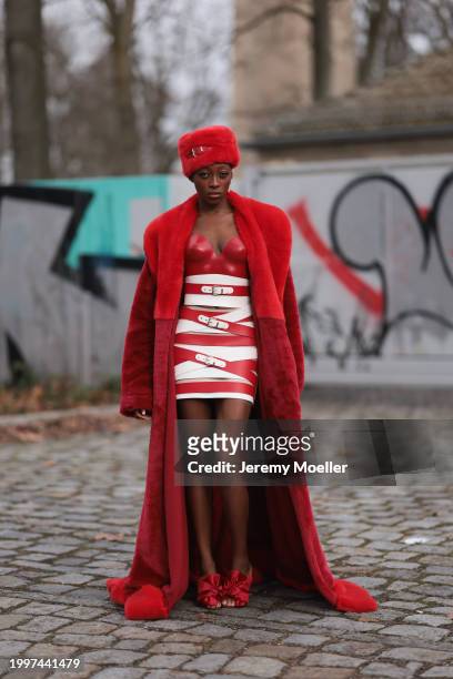 Toni Dreher seen wearing Marina Hoermanseder red belted fake fur fluffy hat, Marina Hoermanseder red / white leather striped belted corset short...