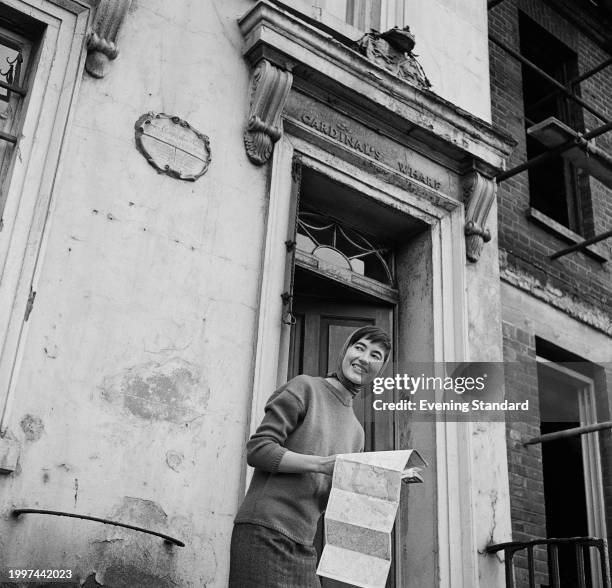 Tourist holds a map outside 49 Bankside on the South Bank, London, July 18th 1957.