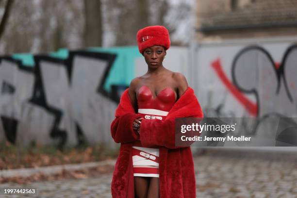 Toni Dreher seen wearing Marina Hoermanseder red belted fake fur fluffy hat, Marina Hoermanseder red / white leather striped belted corset short...