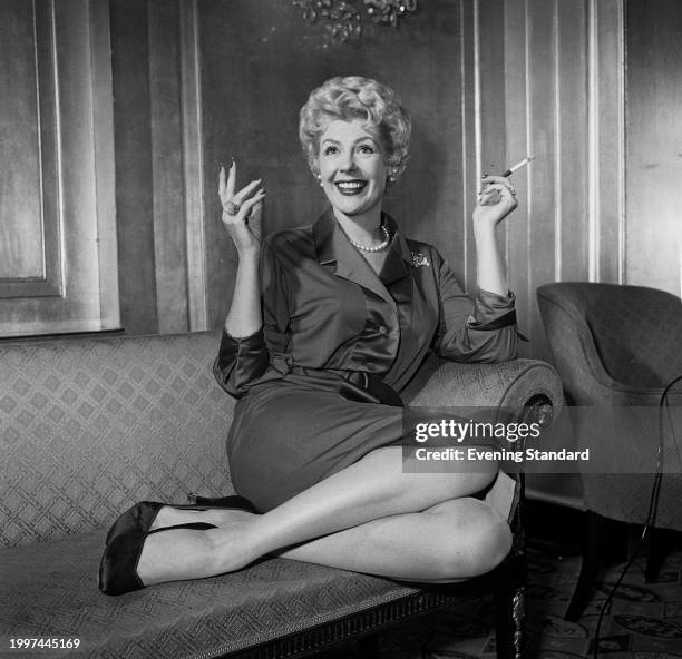 American singer Marie McDonald reclining on a chaise longue, London, July 19th 1957.