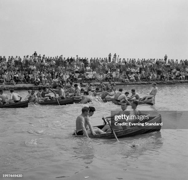 Crowd of people watch men in their swimwear rowing boats at Butlins Holiday Camp, Clacton-on-Sea, Essex, August 1st 1956.