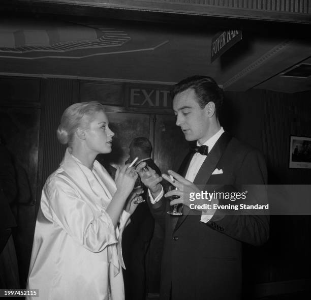 Actor Richard Johnson lights a cigarette for actress Mary Ure August 8th 1956.