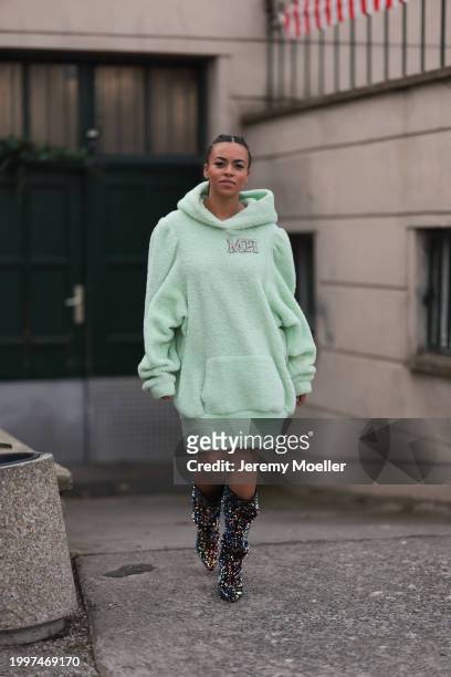 Aminata Belli seen wearing Marina Hoermanseder pastel green pearl embroidered logo teddy fur oversized hoodie / sweater dress, Buffalo x Marina...