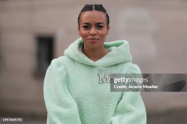 Aminata Belli seen wearing Marina Hoermanseder pastel green pearl embroidered logo teddy fur oversized hoodie / sweater dress, on February 08, 2024...