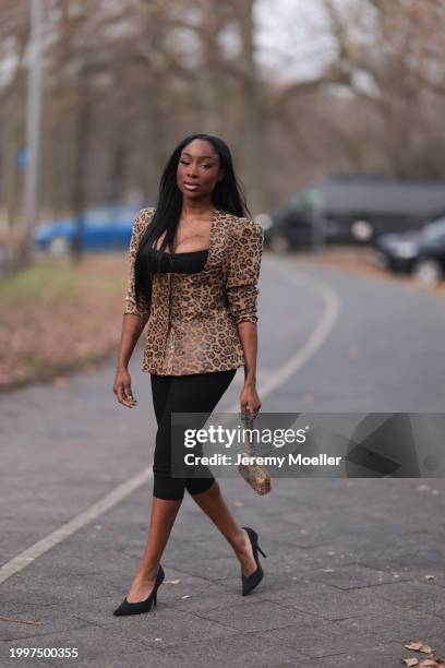 Sandra Lambeck seen wearing black satin bra top, Marina Hoermanseder beige / brown leo print pattern corsage top with puff sleeves, gold rings,...