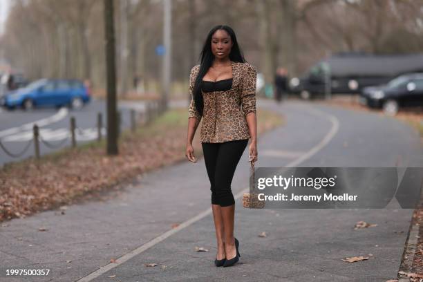 Sandra Lambeck seen wearing black satin bra top, Marina Hoermanseder beige / brown leo print pattern corsage top with puff sleeves, gold rings,...