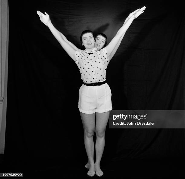 Identical twins Pamela and Pauline Chamberlain forming the letter 'Y' with their bodies, November 1955. Pamela and Pauline are dancers from...