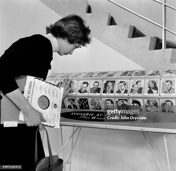 Woman viewing a rotating display of musical artists at the HMV record shop at 363 Oxford Street, London, November 1955.