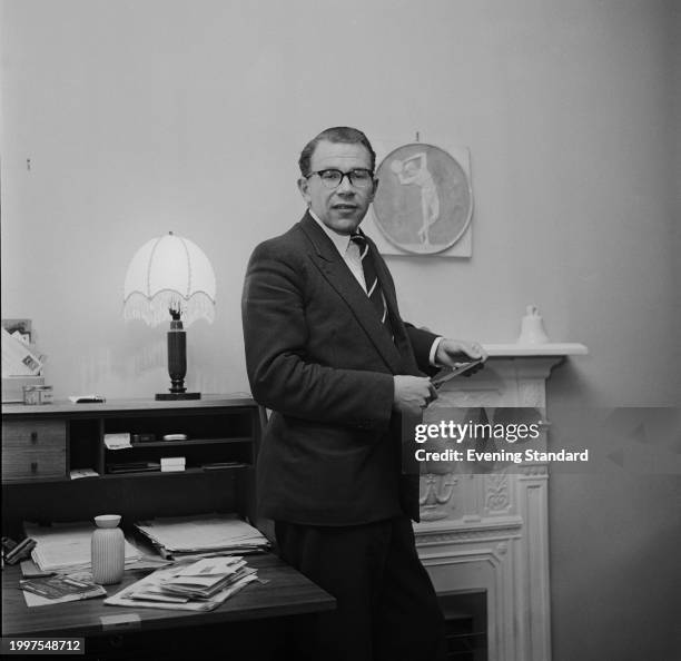 British athlete Chris Brasher standing beside his bureau, January 16th 1957. Brasher won the Men's 3000m Steeplechase gold medal at the Melbourne...