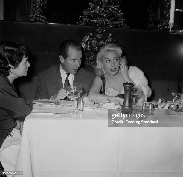 Director Terence Young dining with French actress Martine Carol , January 17th 1957.