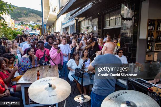 South Africans enjoy a glass of wine and a jazz jam session at the Openwine wine bar on January 28, 2024 in trendy downtown Cape Town, South Africa....