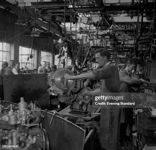 Man works on an engine at the BMC Austin Longbridge car plant, Birmingham, June 26th 1957.