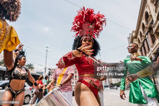 portrait of a mid adult woman playing tambourine at a street carnival party - school fete stock pictures, royalty-free photos & images