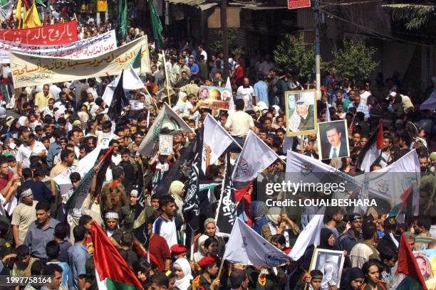 Carrying banners and flags, some of the 3000 people march during a rally at the Yarmuk Palestinian refugee camp close to Damascus 28 September 2002....