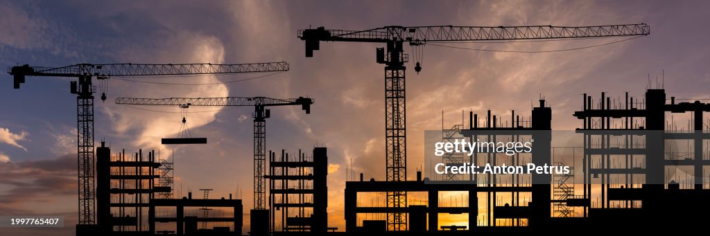 Construction site with cranes at sunset