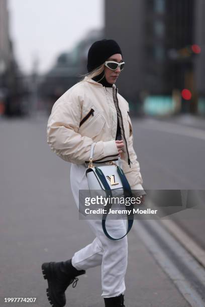 Sonia Lyson seen wearing Bottega Veneta white sunglasses, & Other Stories black wool knit balaclava, black wool knit sweater, Kway off-white bomber...