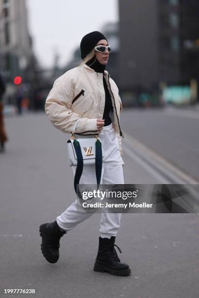 Sonia Lyson seen wearing Bottega Veneta white sunglasses, & Other Stories black wool knit balaclava, black wool knit sweater, Kway off-white bomber...