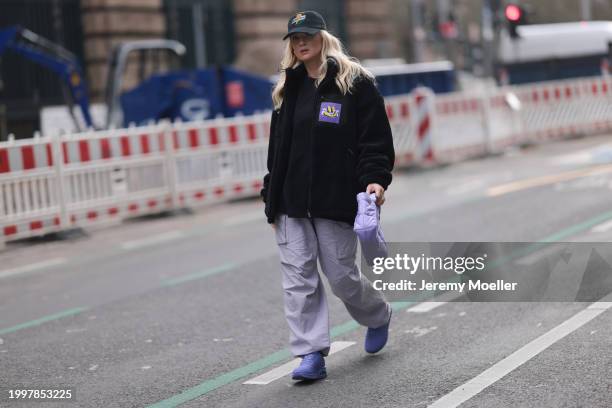 Palina Kozyrava seen wearing Vertere black logo pattern cap, Vertere black logo patch fleece jacket, Vertere black logo print pattern cotton t-shirt,...