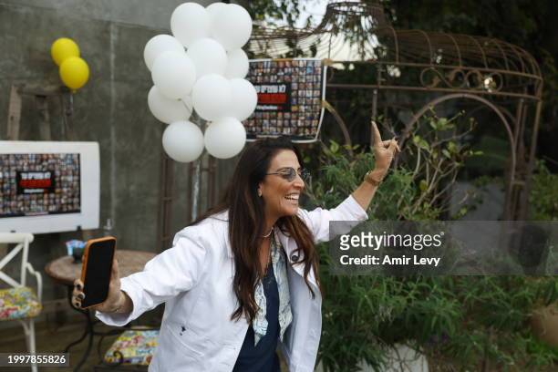 Hagit Matzliah takes off a kidnapped sign from the store where rescued hostage, Fernando Marman, worked in Ramat Hasharon on February 12, 2024 in Tel...