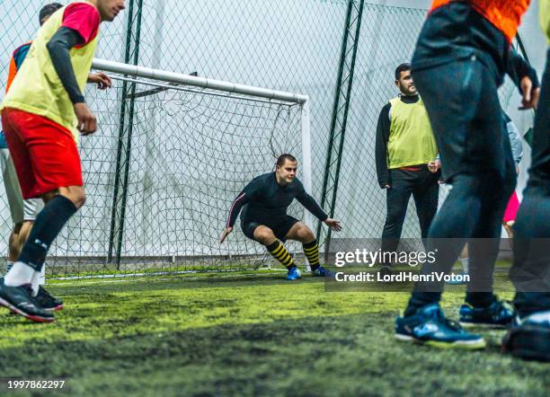 goalkeeper defending goal in soccer game - futsal pitch stock pictures, royalty-free photos & images