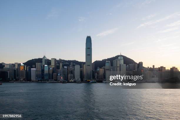 victoria harbor in hong kong at twilight - isla de hong kong fotografías e imágenes de stock