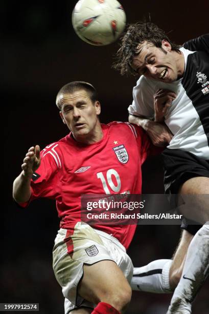 February 9: Michael Owen of England and Joris Mathijsen of Netherlands challenge during the International Friendly match between England and...