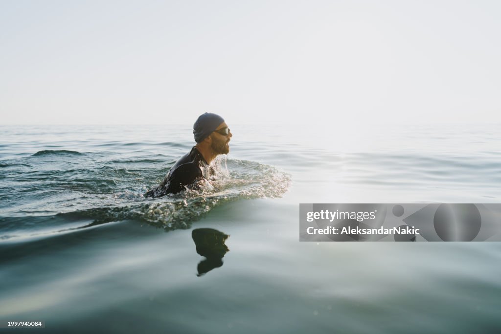 Männlicher Athlet schwimmt im Meer