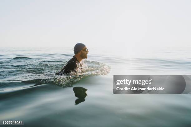 male athlete swimming in the sea - professional swimmer stock pictures, royalty-free photos & images