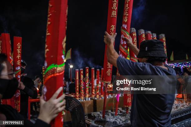 Volunteer places large incense sticks at Sze Yup Kwan Ti temple on Lunar New Year's Eve on February 09, 2024 in Sydney, Australia. Lunar New Year was...