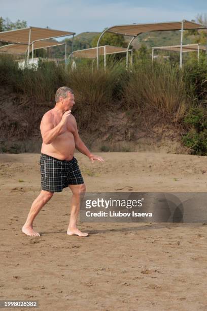 sport on vacation. senior man practicing tai chi outdoors - senior men stock pictures, royalty-free photos & images