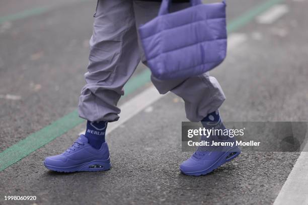 Palina Kozyrava seen wearing pastel purple nylon cargo pants, Vertere purple cotton logo smiley print pattern socks, purple nylon quilted bag and...