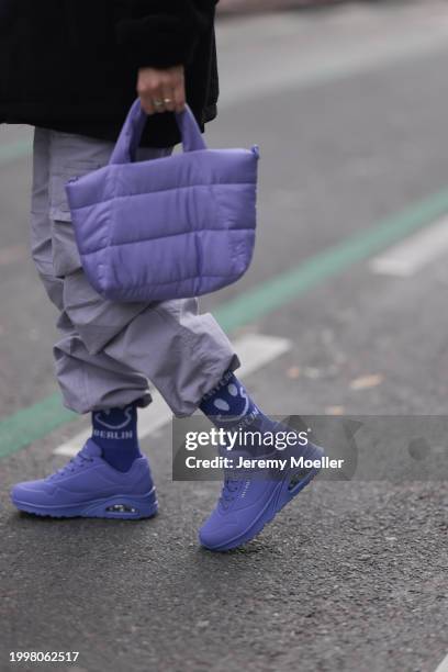 Palina Kozyrava seen wearing Vertere black logo patch fleece jacket, pastel purple nylon cargo pants, Vertere purple cotton logo smiley print pattern...