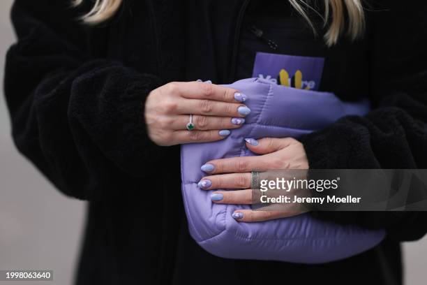 Palina Kozyrava seen wearing Vertere black logo patch fleece jacket, purple nylon quilted bag, silver / gold rings, on February 08, 2024 in Berlin,...
