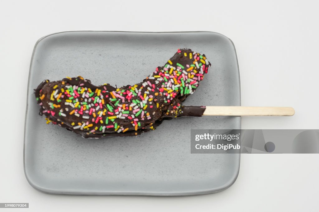 Chocolate-Dipped Banana with Sprinkles on a Plate