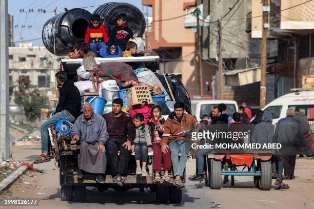 Members of a Palestinian family ride in the back of a truck with belongings as they flee Rafah in the southern Gaza Strip taking the coastal road...