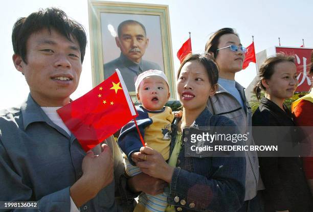 Chinese family stand beneath a portrait of Sun Yat Sen, considered the founder of modern China after helping overthrow dynastic rule in 1911, 01...