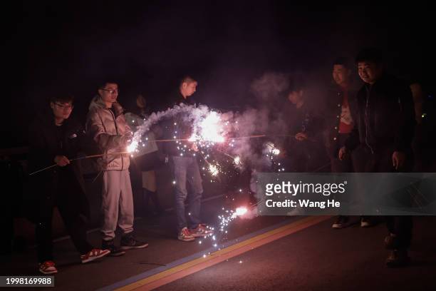 People let off firecrackers to celebrate the Spring Festival at a community open space on February 9,2024 in Huanggang, Hubei Province, China. China...