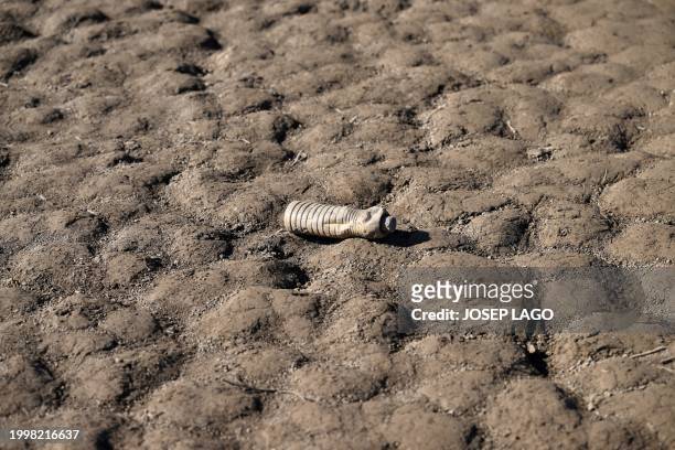 This photograph shows a plastic bottle on the banks of the low water-level reservoir of Sau in the province of Girona in Catalonia, on February 12,...